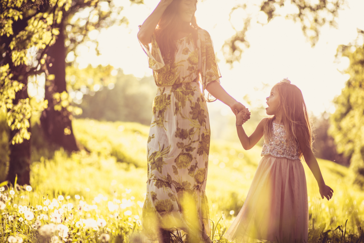 A lady and child holding hands in sunshine
